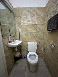 a bathroom with a toilet and a sink at Le bungalow by mk in Nzogobeyork