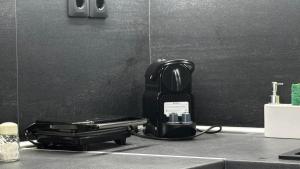 a black coffee maker on a counter in a bathroom at L'aTTIQUE in Kastanéa
