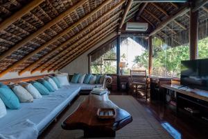 a living room with a large couch and a television at Hotel e Resort Villas de Trancoso in Trancoso
