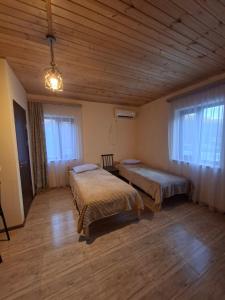 a bedroom with two beds and a wooden ceiling at Shen toon cottage in Shnogh