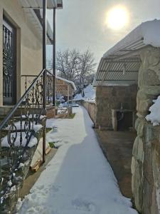 a snow covered walkway next to a building at Shen toon cottage in Shnogh