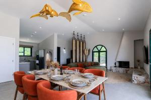 a dining room with a table and orange chairs at Xenia Sea view Villa in Argassi