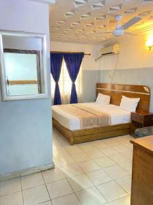 ein Schlafzimmer mit einem Bett und einem Fenster in der Unterkunft Embel Hotel in Port Harcourt
