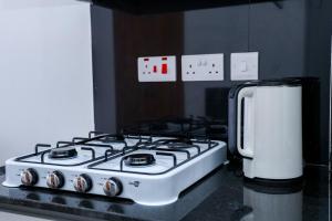 a stove top oven sitting on a counter next to a refrigerator at Onkundis Luxury Homes in Kiambu