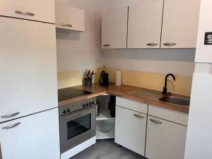 a kitchen with white cabinets and a sink and a stove at Ferienhaus Michi in Ursprung