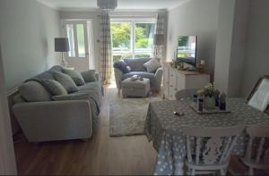 a living room with a couch and a table at 2 Bedroom Garden Flat in Halesworth