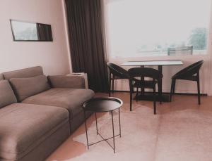ein Wohnzimmer mit Sofa, Tisch und Stühlen in der Unterkunft Silver Lotus in De Haan + 3 Fotos