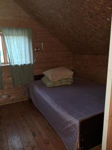 a bed in a wooden room with a window at Huntingbox in Purila