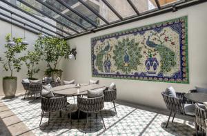 a tapestry on the wall of a restaurant with tables and chairs at Casa Talavera by Tasman in Mexico City
