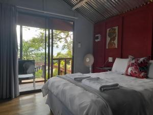 a bedroom with a large bed and a large window at Entendeni Lodge SelfCatering in Inanda