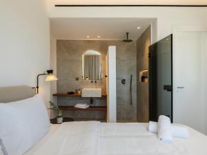 a bedroom with a white bed and a shower at Vendema Residence Mykonos in Mikonos +34 photos