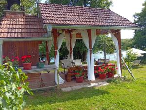 a gazebo with flowers in pots in a yard at Kuća za odmor Una in Dvor +18 photos
