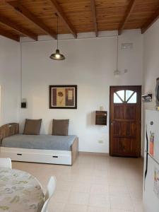 a bedroom with a bed and a table and a refrigerator at Alvear Departamento B in Venado Tuerto