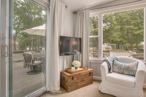 a living room with a television on a porch at Charming Cape Cod Water-View Cottage in Mashpee