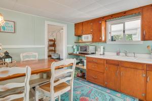 a kitchen with wooden cabinets and a wooden table and chairs at Charming Cape Cod Water-View Cottage in Mashpee