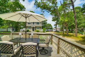 a table with an umbrella on a deck at Charming Cape Cod Water-View Cottage in Mashpee