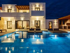 a villa with a swimming pool at night at Vendema Residence Mykonos in Mikonos