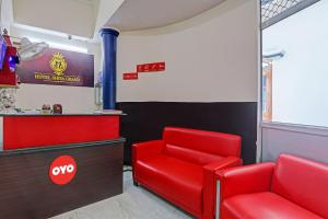 a waiting room with a red chair and a counter at Hotel O Shiva Grand in Chinhat