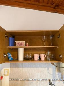 a kitchen shelf with bowls and glasses on it at Alvear Departamento B in Venado Tuerto +11 photos