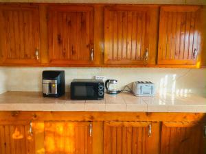 a kitchen counter with a microwave and a toaster at Home & Heart Gambia in Brusubi