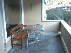 ein Tisch und Stühle auf einem Balkon mit Fenster in der Unterkunft Viamalablick in Thusis