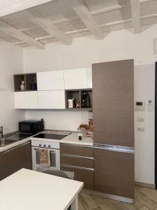 a kitchen with white and brown cabinets and a table at Jblago in Arona