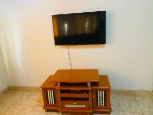 a flat screen tv on a wall with a wooden table at Home & Heart Gambia in Brusubi