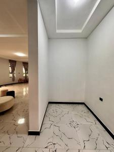 a room with a white wall with a marble floor at Hilm cottage in Āwasa