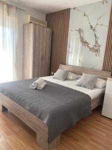 a bedroom with a large bed with two towels on it at New Apartments Blue in Ulcinj