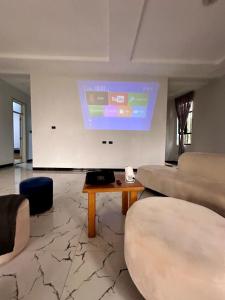 a living room with a couch and a projection screen at Hilm cottage in Āwasa