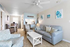 a living room with a couch and a table at Gulf Winds Resort by Travel Resort Services in St. Pete Beach