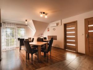 a dining room with a wooden table and chairs at Pokoje Gościnne Wróblówka in Laskowa