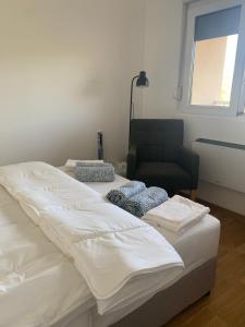two beds in a room with a chair and a window at Apt Moravica in Soko Banja +20 photos