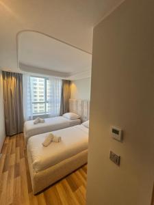 a bedroom with two beds and a window at Hilton Tanger View Tower 15D in Tangier