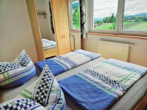 two beds in a room with two windows at Ferienwohnungen Simon - Hauserhof in Oberperfuss