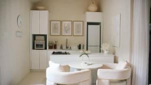 a white kitchen with a table and two chairs at Villa Zen - 1 Bedroom Studio in Saint James