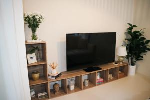 a flat screen tv sitting on a wooden entertainment center at Villa Zen - 1 Bedroom Studio in Saint James