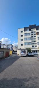 a parking lot in front of a large building at Apartament OAȘUL 2 in Hurez