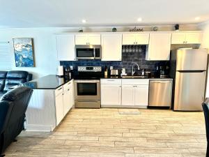 a kitchen with white cabinets and stainless steel appliances at Sunset by the Sea 3054 in Fort Myers Beach
