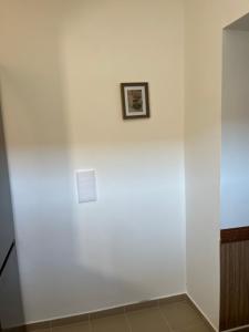 a white wall with a picture on it at Mazsola apartman in Hódmezővásárhely