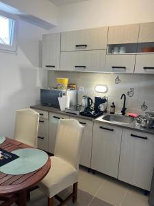 a kitchen with a table and chairs and a sink at Mazsola apartman in Hódmezővásárhely