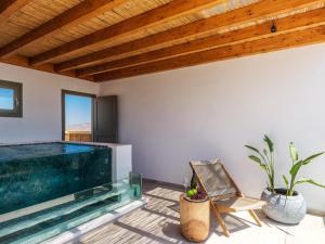 a swimming pool in a living room with a wooden ceiling at Vendema Residence Mykonos in Mikonos