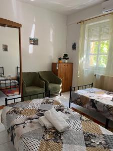 a living room with two beds and a couch at Mazsola apartman in Hódmezővásárhely