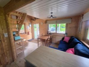 a living room with a blue couch and a table at Mazury na Miedzy in Orzyny