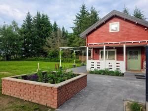 a red house with a garden in front of it at Mazury na Miedzy in Orzyny