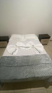 a bed with white sheets on top of it at Sítio Jorema in Camanducaia +28 photos