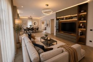 a living room with a large couch and a television at Villa Krasta in Elbasan