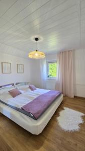 a large white bed in a bedroom with a chandelier at Baltic House in Kopalino