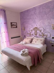 a bedroom with a large bed with purple walls at Villa G&G in Tropea