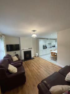 a living room with two couches and a dining room at CamCosy Retreat in Gortin +8 photos